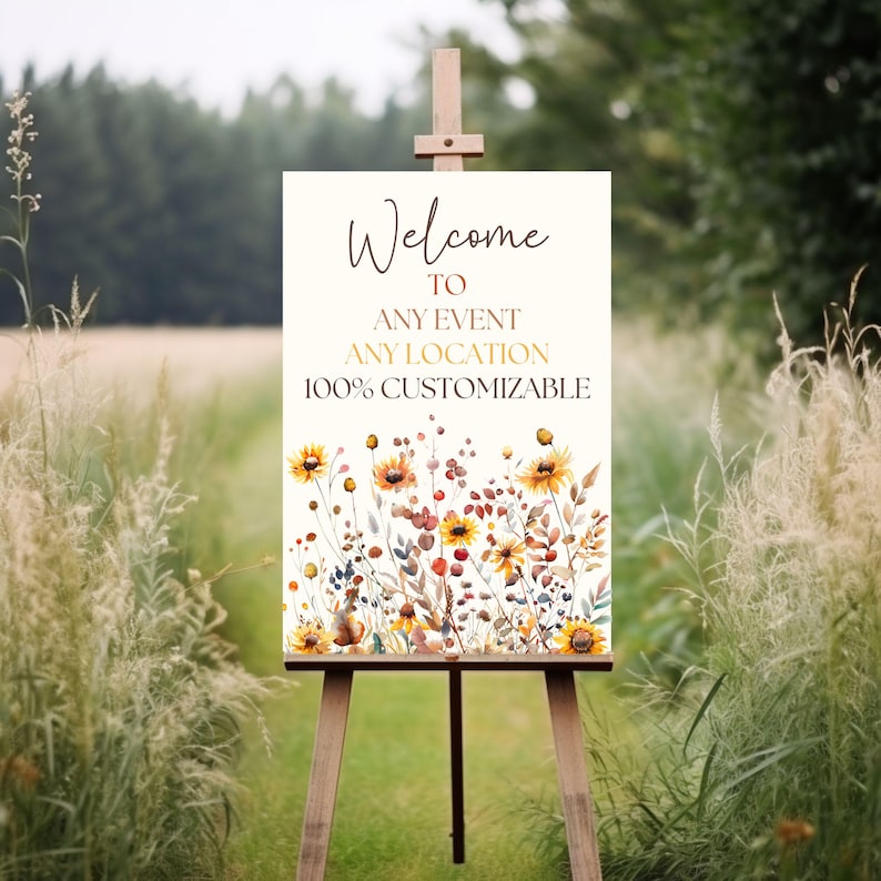 May include: A wooden easel displays a welcome sign with floral artwork. The sign reads "Welcome to Any Event Any Location 100% Customizable" in elegant script. The floral design features yellow sunflowers and other wildflowers.