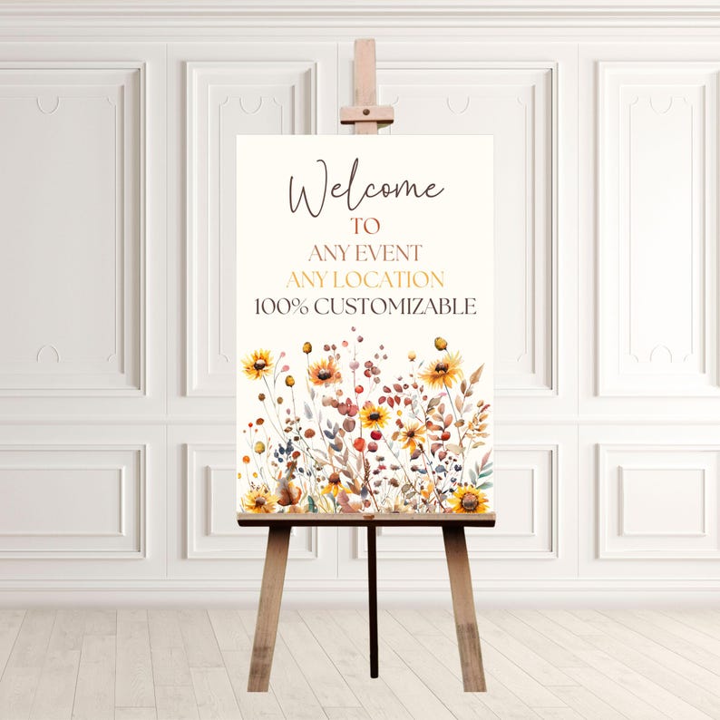 May include: A wooden easel displays a welcome sign with floral artwork. The sign reads "Welcome to Any Event Any Location 100% Customizable." The floral design features yellow, orange, and red flowers with green and brown foliage.