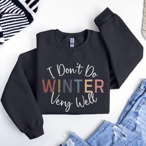 May include: Black sweatshirt with the text "I Don't Do Winter Very Well" in a colorful vintage style font.