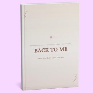 Op de afbeelding: Een hardcover boek met een crèmekleurige kaft en de titel BACK TO ME in donkerbruine letters. De kaft bevat de ondertitel 30-DAY HEALTHY HABITS & WEIGHT LOSS JOURNEY FOR WOMEN 40+ en de zin Small steps. Better habits. More you.