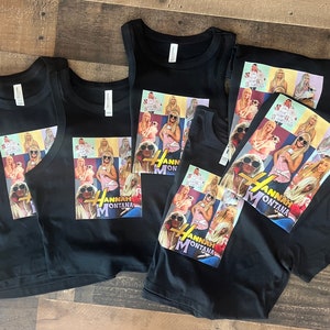 May include: Four black tank tops and a black t-shirt with a collage of images of Miley Cyrus as Hannah Montana. The images are in a grid pattern and include a variety of poses and outfits. The text "Hannah Montana" is printed in gold letters below the images.
