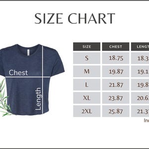 Puede incluir: Una camiseta azul marino con una tabla de tallas. La tabla muestra las medidas de pecho y largo en pulgadas para las tallas S, M, L, XL y 2XL. El texto "SIZE CHART" est&aacute; en la parte superior.