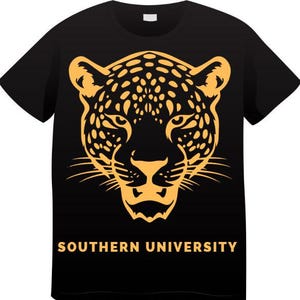 May include: Black t-shirt featuring a gold-colored jaguar head design. The design includes spots and facial details. The words "SOUTHERN UNIVERSITY" are printed in gold below the jaguar head. The shirt is a crew neck.