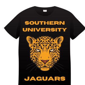 May include: Black t-shirt featuring a detailed illustration of a jaguar's face in shades of orange and yellow. The text "SOUTHERN UNIVERSITY" and "JAGUARS" are printed in gold above and below the jaguar graphic.