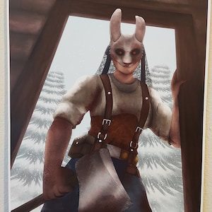 Puede incluir: Una mujer con una máscara de conejo blanca con ojos rojos y un velo de encaje blanco sostiene un hacha. Lleva una camisa a rayas blancas y marrones, un mono marrón y pantalones vaqueros azules. El fondo es un bosque nevado.