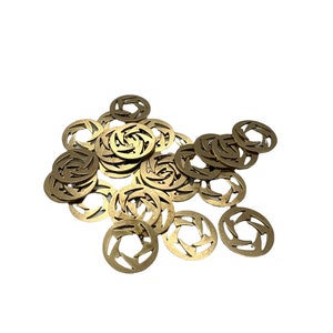 May include: A pile of gold-colored metal charms with a swirling design. The charms are round and have a cut-out design in the center.