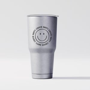 K&ouml;nnte beinhalten: Ein silberner Edelstahlbecher mit einem schwarzen Smiley-Gesicht und dem Text "Choose Happy", der sich um das Gesicht wiederholt.
