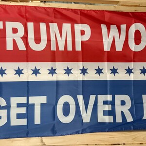 May include: A red, white, and blue flag with the text "TRUMP WON! GET OVER IT!" printed in white. The flag has a row of white stars on a blue stripe.