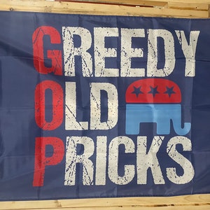 Può includere: Una bandiera blu con il testo "GREEDY OLD PRICKS" in lettere bianche con contorni rossi. Il testo è in un font usurato. Un elefante blu con una stella rossa sulla testa è al centro della bandiera.