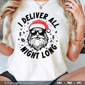Puede incluir: Camiseta blanca con un gr&aacute;fico negro y rojo de Pap&aacute; Noel con el texto "I Deliver All Night Long".