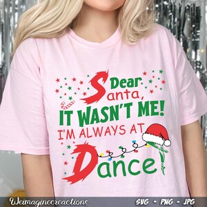 Könnte beinhalten: Rosa T-Shirt mit einer grünen und roten Grafik, auf der steht "Lieber Weihnachtsmann, es war nicht ich! Ich bin immer beim Tanzen".