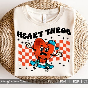 Op de afbeelding: Een wit T-shirt met een rode hartgrafiek die skateboardt met de tekst "HEART THROB" in zwarte letters.