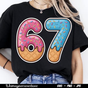 May include: Black t-shirt featuring a colorful graphic of the number "67" designed as donuts. The "6" is pink with sprinkles, and the "7" is blue with sprinkles. The numbers have a waffle cone base.