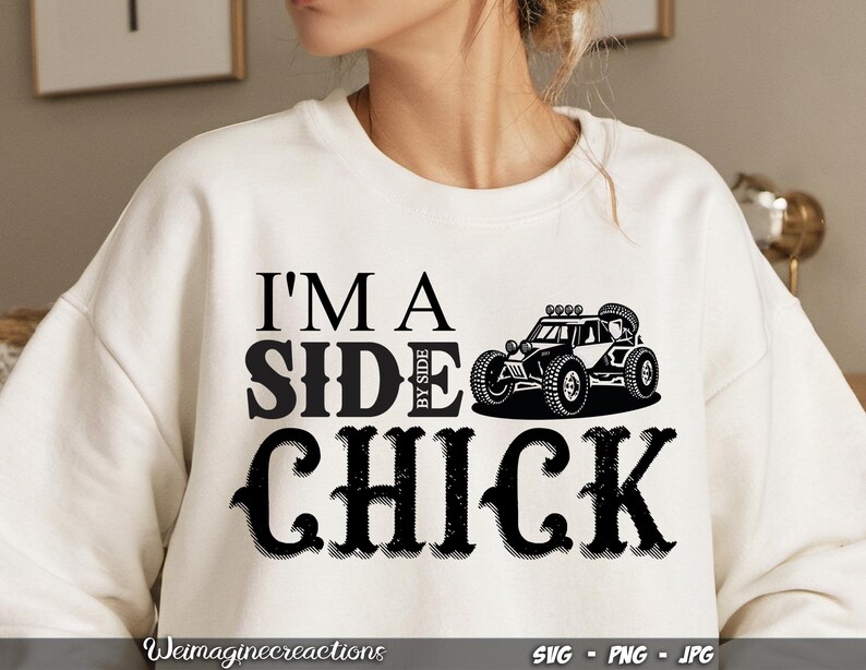May include: White sweatshirt with black text that reads "I'm a Side by Side Chick" and a black silhouette of a side-by-side vehicle.