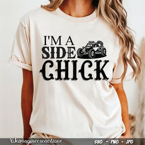 May include: A white t-shirt with black text that reads "I'm a Side By Side Chick" and a black silhouette of a side-by-side vehicle.