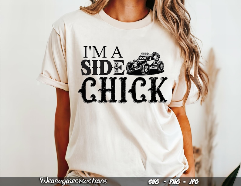 May include: A white t-shirt with black text that reads "I'm a Side By Side Chick" and a black silhouette of a side-by-side vehicle.