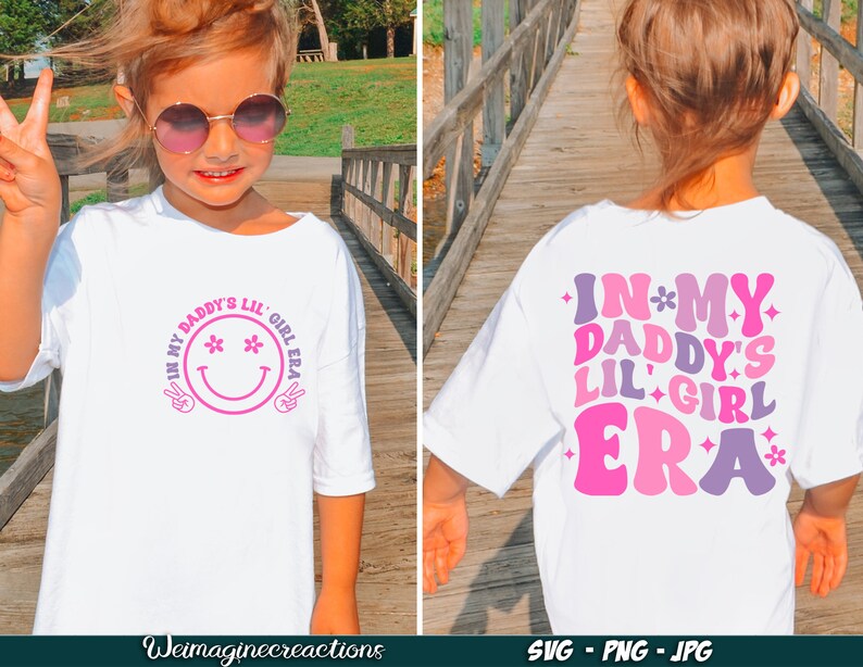 Peut inclure: T-shirt blanc avec un motif rose et violet qui dit "In My Daddy's Lil' Girl Era" avec un smiley sur le devant et un motif similaire au dos.