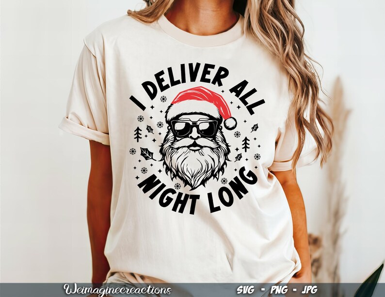 Puede incluir: Una camiseta blanca con un gr&aacute;fico negro y rojo de Pap&aacute; Noel con gafas de sol y un gorro de Pap&aacute; Noel. El texto "I Deliver All Night Long" rodea el gr&aacute;fico.