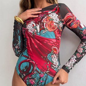Peut inclure: Combinaison noire en maille avec un motif floral et abstrait color&eacute;. Le motif repr&eacute;sente une femme aux cheveux roux flottants et une robe rouge.