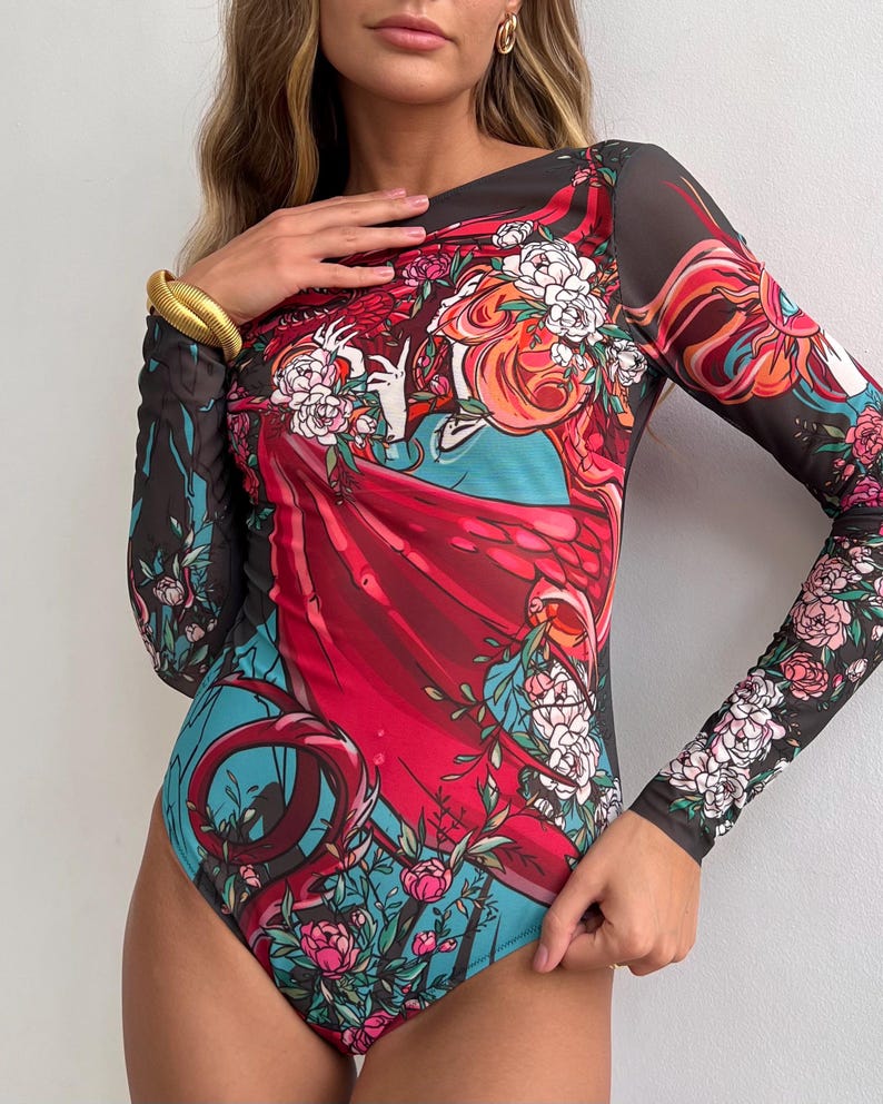 Peut inclure: Combinaison noire en maille avec un motif floral et abstrait color&eacute;. Le motif repr&eacute;sente une femme aux cheveux roux flottants et une robe rouge.