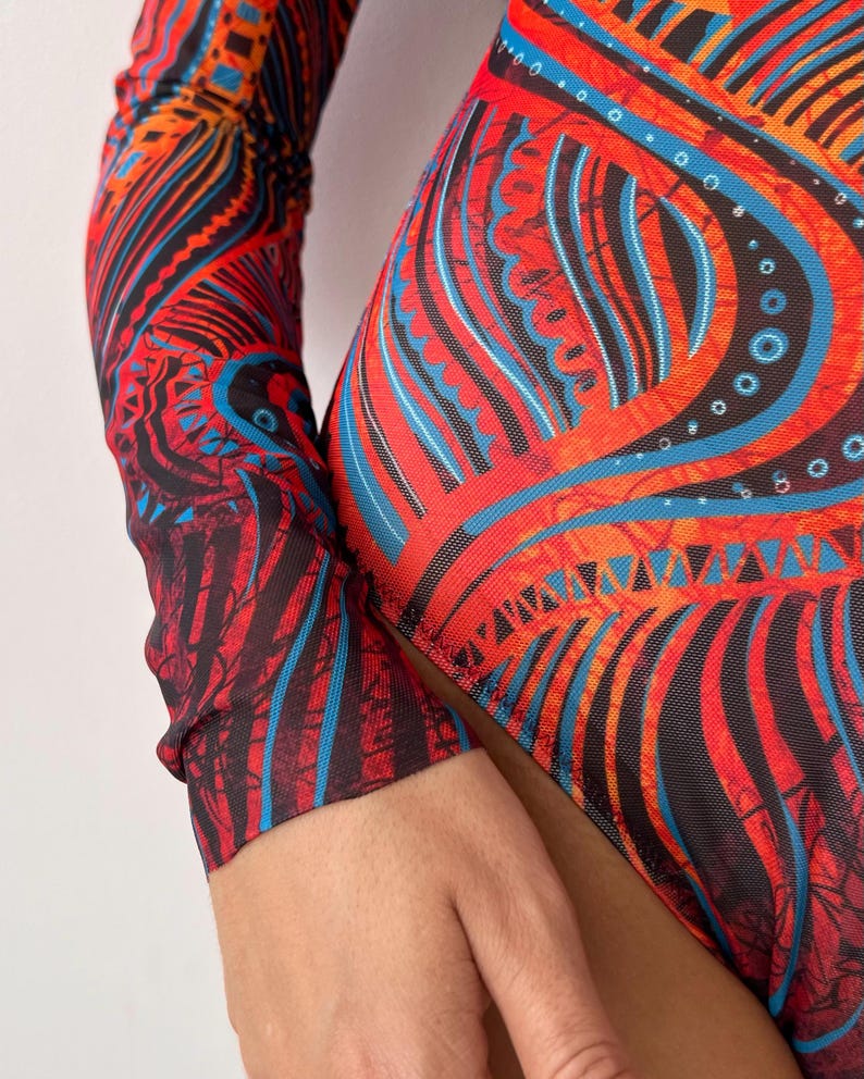 May include: A vibrant, patterned bodysuit featuring a striking design in red, black, and blue. The long-sleeved garment showcases an intricate, abstract pattern with a mesh-like texture, creating a bold and artistic look. The bodysuit's design is eye-catching and suitable for various occasions.