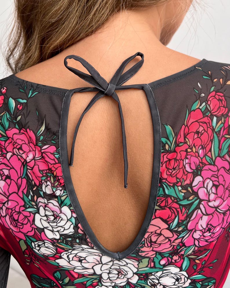 Peut inclure: Haut en maille noire &agrave; imprim&eacute; floral avec des fleurs roses, blanches et vertes. Le haut a un dos en forme de trou de serrure avec un ruban noir.