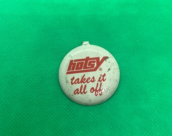 May include: A white round button with red text that reads "Hotsy takes it all off" with a registered trademark symbol.