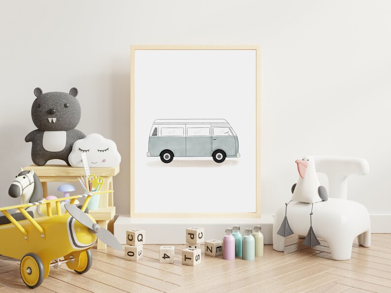 以下が含まれることがあります： 白い窓と車輪が付いた薄い青色のヴィンテージバンを描いた額縁付きのイラスト。イラストは白い背景に描かれており、木製の額縁で囲まれています。額縁は白い壁に置かれています。手前に様々な玩具とブロックがあります。