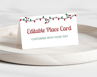 May include: White place card with a red and green string of Christmas lights at the top. The text "Editable Place Card" is in red and the text "Customize with your text" is in green.