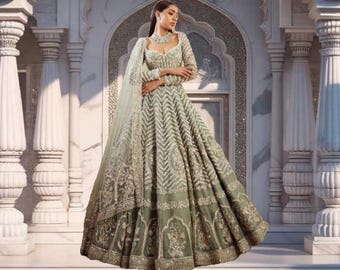 May include: An elegant sage green wedding gown with intricate embroidery and a flowing skirt. The gown features long sleeves and a matching veil. The text "WeddingWear World" is visible in the image.