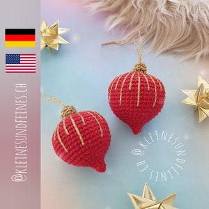 May include: Two red crocheted Christmas baubles with gold thread accents. The baubles are hanging from a string and are on a light blue background.