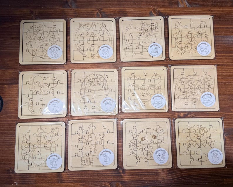 May include: Twelve square wooden jigsaw puzzles arranged in a grid, each featuring a unique laser-engraved animal illustration. The light-coloured wood puzzles are individually wrapped in clear plastic and include a small circular sticker on each.
