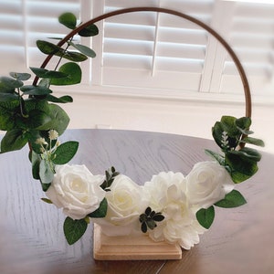 Handmade gold hoop centerpieces with white and ivory artificial flowers with base.