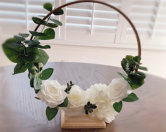 Handmade gold hoop centerpieces with white and ivory artificial flowers with base.