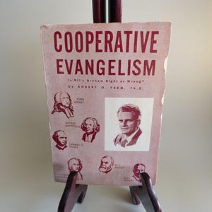Puede incluir: Una portada de libro vintage titulada "COOPERATIVE EVANGELISM" con la pregunta "Is Billy Graham Right or Wrong?" en texto rojo. La portada presenta retratos de figuras históricas y un retrato de Billy Graham.