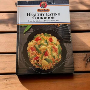 May include: A cookbook titled "Healthy Eating Cookbook" from the kitchens of Uncle Ben's, Inc. The cover features a photo of a bowl of rice with vegetables and a close-up of Uncle Ben's face.