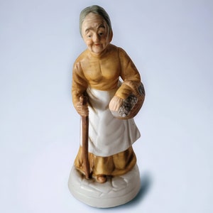 Femme âgée en céramique vintage portant un panier de baies canne/bâton de marche Figurine cheveux gris en chignon Statue unique de collection, décoration d&#39;étagère