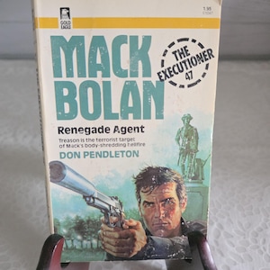 May include: Vintage paperback book titled "Mack Bolan Renegade Agent" by Don Pendleton. The cover features a man holding a gun, with the text "The Executioner 47". The book has a yellow and teal color scheme.