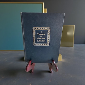 Puede incluir: Una taza de cerámica blanca con un asa negra y el texto "But First, Coffee" en un estilo manuscrito. La taza está sobre una superficie blanca. La taza mide aproximadamente 10 cm de alto.