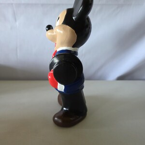 K&ouml;nnte beinhalten: Vintage Mickey Mouse Figur, bemalt in Schwarz, Beige, Rot, Blau und Braun. Die Figur tr&auml;gt eine blaue Jacke mit roten und wei&szlig;en Akzenten, einen schwarzen Hut und braune Schuhe. Ein Sammlerst&uuml;ck.