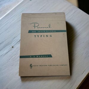 Pode incluir: Um livro vintage intitulado "Personal and Professional Typing" de S. J. Wanous. O livro tem uma capa bege com texto verde-azulado e preto. O livro é da South-Western Publishing Company.