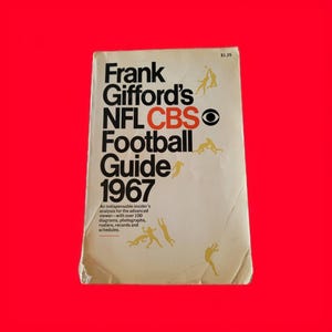 Könnte beinhalten: Ein Vintage-Buchcover für Frank Giffords NFL CBS Football Guide aus dem Jahr 1967. Der Umschlag ist weiß mit schwarzem Text und einem CBS-Augenlogo. Das Buch kostet 1,25 $.