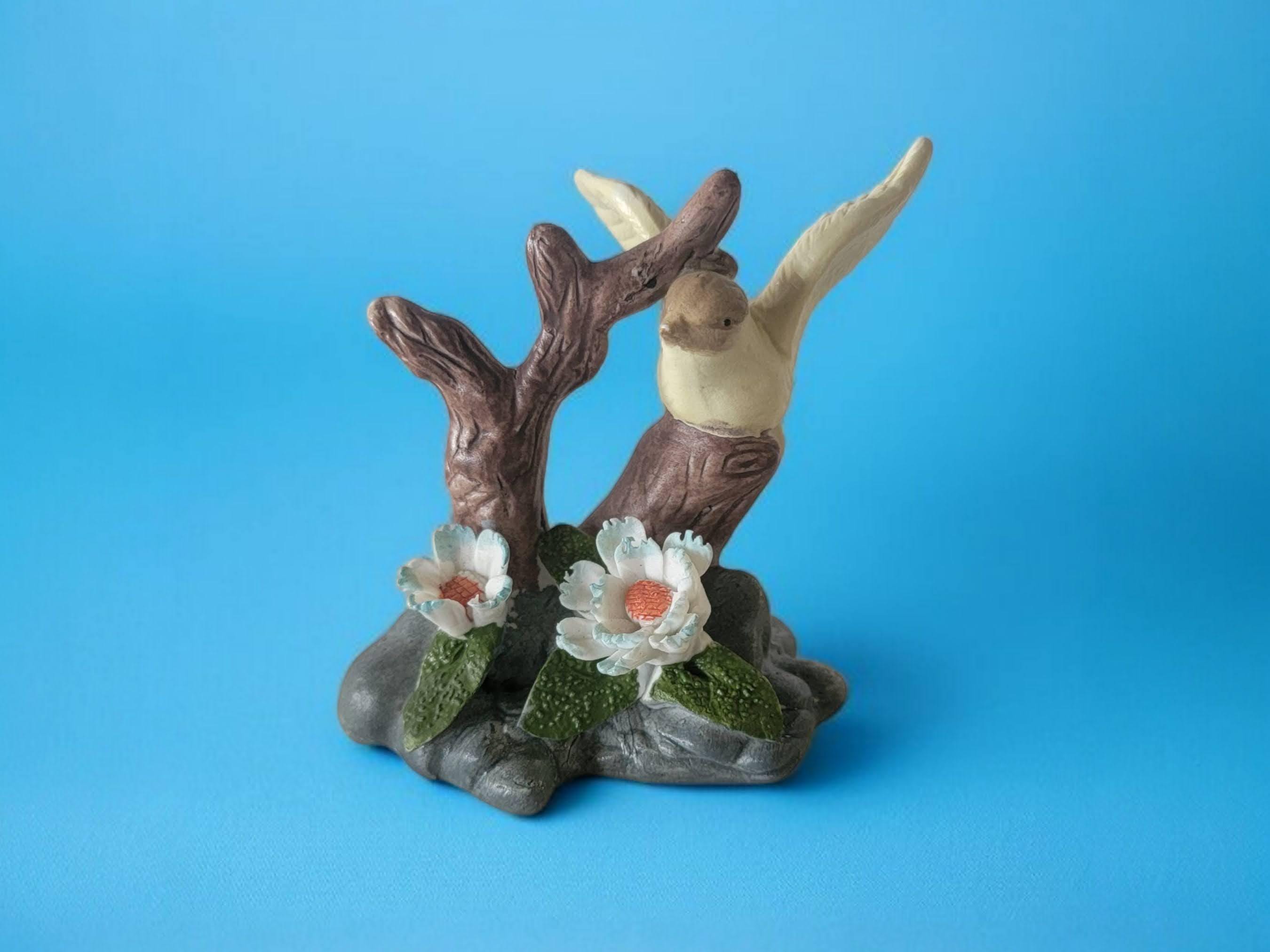 3Dの青と白の花が付いた小さな磁器の鳥の置物、木の枝と岩の上にいる