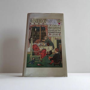 May include: Vintage book titled "A Book of Verses for Children" with a colorful illustration of children gathered around a table. The cover features a detailed drawing of a cozy interior scene with figures in period clothing.