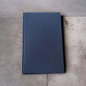 May include: A dark blue hardcover book with a textured cover.
