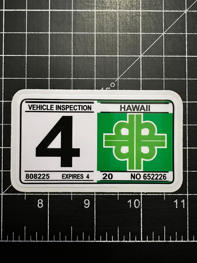 May include: A white sticker with black text and a green background. The sticker says "VEHICLE INSPECTION" and "HAWAII". The number "4" is in the center of the sticker. The sticker also has the numbers "808225", "20", and "652226".