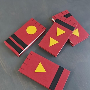 K&ouml;nnte beinhalten: Vier rechteckige rote Notizb&uuml;cher mit wei&szlig;en Seiten. Jeder Einband ist mit schwarzen Streifen und gelben geometrischen Formen wie Kreisen und Dreiecken versehen. Die Einb&auml;nde haben kleine schwarze Einkerbungen an einer Kante.
