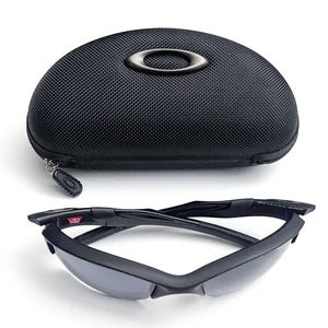 May include: Black sunglasses with a matching black case. The sunglasses have a sleek, modern design with dark lenses and a black frame. The case is oval-shaped with a zipper closure and the brand logo.