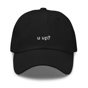 May include: A black baseball cap with the text "u up?" embroidered in white on the front.