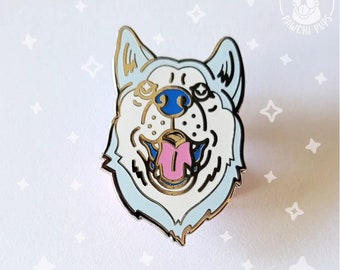 May include: A white and blue enamel pin of a dog with its tongue sticking out. The dog has a blue nose and a gold outline. The pin is on a white background with white stars.